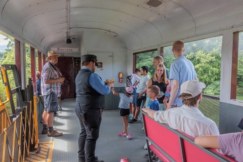Young family watches a ticket collector punch their souvenir tickets on the Great Smoky Mountains