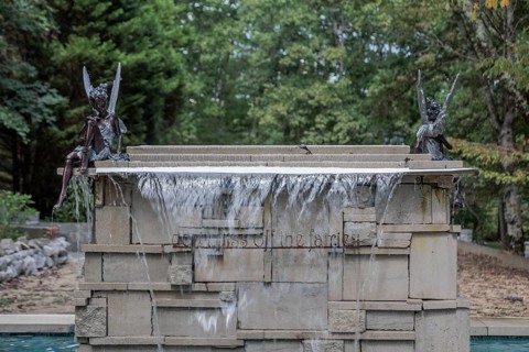 Water fountain with fairies and a sign reading Don't piss off the fairies near the entrance to