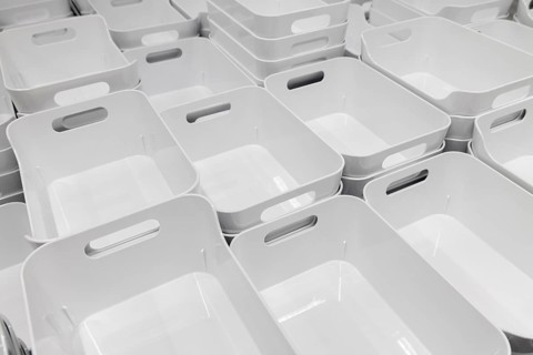White plastic baskets neatly stacked in rows in the showroom section of the IKEA home store