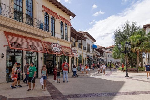 Shoppers and visitors walking past Ron Jon Surf Shop in Disney Springs at Disney World in Orlando,