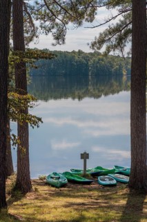 Plastic rental kayaks, canoes and paddleboards on the shore of Pin Oak Lake at The Lodge hotel in