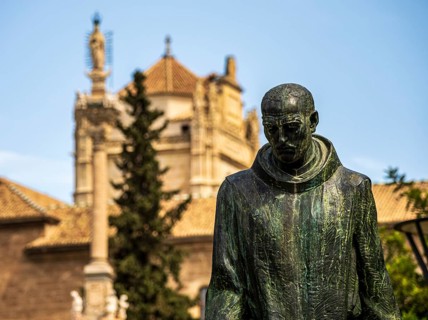 Statue of Johannes von Gott, Granada, royal hospital in the back, Granada, Andalusia, Spain