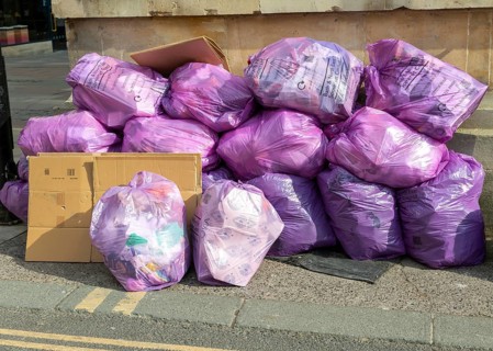 Council bags of rubbish waste piled on street corner, city of Bath, north east Somerset, England,