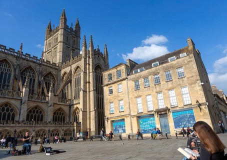 Busker musician performing in Bath Abbey church yard, city of Bath, north east Somerset, England,