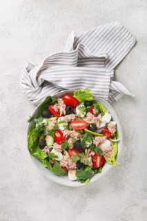 Salad with canned tuna, vegetable salad with quail eggs, lettuce and romaine leaves, red onion,