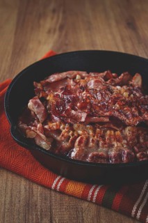 Crispy bacon, on a cast-iron skillet, on a wooden table, rustic style, no people