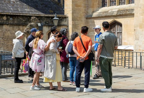 Tour guide with group people at Bath Abbey church, city of Bath, north east Somerset, England, UK