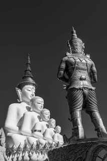 Five-headed Buddha statue with a temple guard in front of it, black and white photo, Wat Phra That