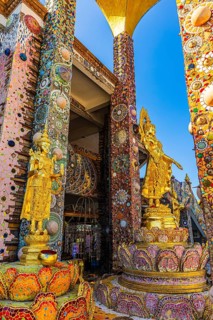 Gilded Buddha statues standing on pedestals decorated with mosaics and glass works of art, Buddhist