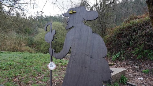 Wooden figure of a pilgrim on the side of the Camino de Santiago, pilgrims on the Caminho