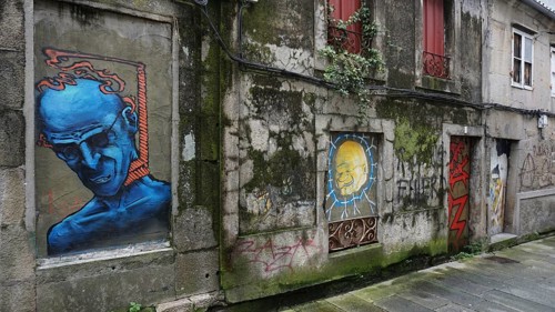 Graffiti on an old building wall with blue figure and other drawings, pilgrims on Caminho