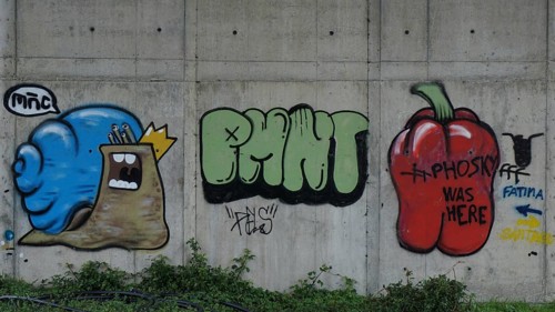 Colourful graffiti of snails and peppers on a concrete wall in an urban setting with Fatima and
