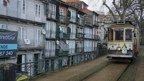 Historic tram runs along a street with old buildings, pilgrims on the Caminho Portugues, Portugal