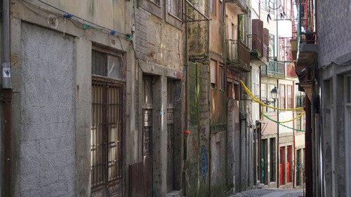 Narrow alley with old, weathered buildings and several balconies in Santiago de Compostela,
