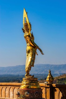 Standing gilded Buddha statue on a viewing terrace, Wat Phra That Sorn Kaew Buddhist temple