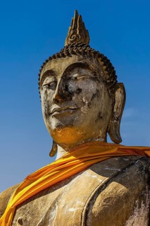 Stone Buddha statue decorated with yellow cloth, historic Buddhist temple complex, Ayutthaya,