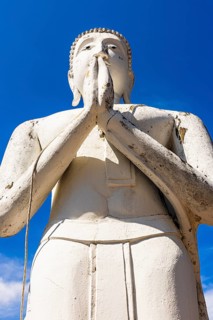 Stone praying white Buddha statue, historic Buddhist temple complex, Ayutthaya, Thailand