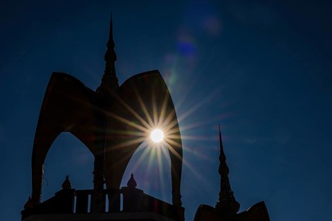 The sun shines through a round arch pavilion, Wat Phra That Sorn Kaew Buddhist temple complex,