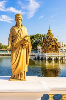 Stone female figure on Dolls Bridge, in the back the open, gilded pavilion, Buddhist temple