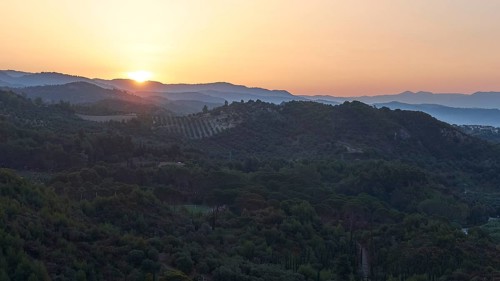Wide landscape with hills at dusk, sunset behind the mountains, Hotel Europa, garden restaurant and