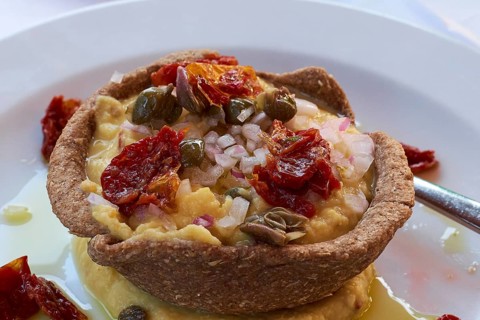 Mediterranean starter with fresh ingredients such as dried tomatoes and capers on a plate, Hotel