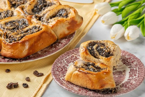 Freshly baked poppy seeds on a plate, next to tulips