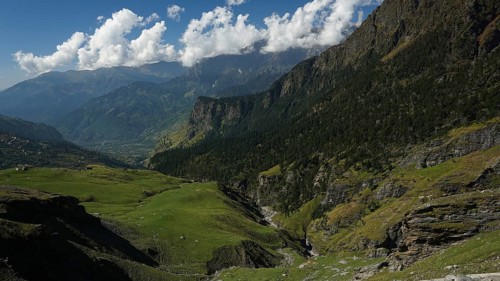 Green valleys and mountains under a partly cloudy sky, trekking in Ladakh, Manali-Leh Highway,