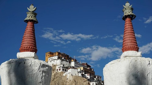 View through two stupas towards Thiksey monastery on a hill under blue sky, Indus Valley, trekking