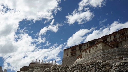 Stone Buddhist monastery building under a dramatic sky full of clouds, trekking in Ladakh,