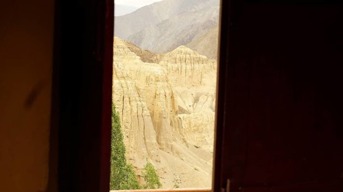 View from a dark window of a rocky, desert-like mountain landscape, trekking in Ladakh, Himalayas,