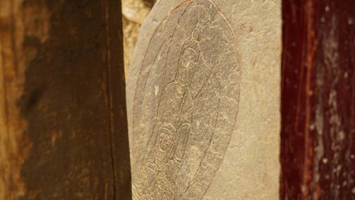 A stone slab with carved Buddha relief as a sacred work of art, trekking in Ladakh, Himalayas,