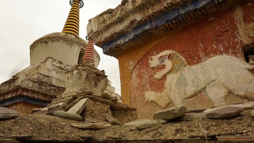 Historic temple wall with lion relief and stupa decoration in an old complex, trekking in Ladakh,