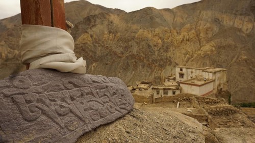 An engraved Mani stone in a mountainous landscape, near an ancient monastery, Leh, trekking in