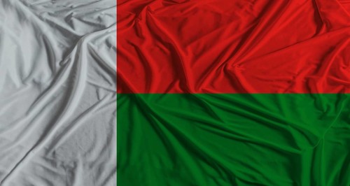 Madagascar flag with fabric texture background. National flag of Madagascar with cloth texture