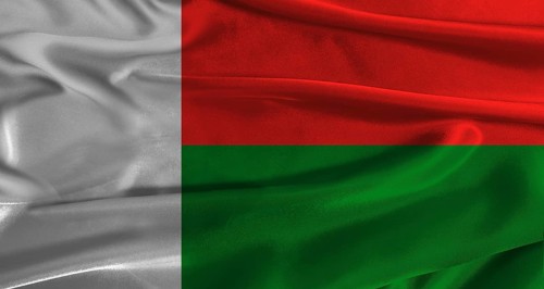 Flag of Madagascar with fabric textured background. Close up of National flag of Madagascar with