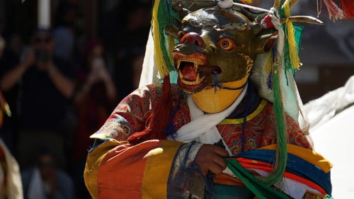 Person in traditional costume with mask dance in festive atmosphere, Leh, trekking in Ladakh,