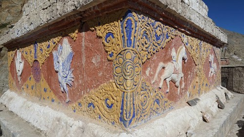 An artfully decorated relief with colorful patterns and symbols on a stone wall, Leh, trekking in