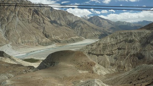 Wide view of a river valley on the way to the Nubra Valley, surrounded by lofty mountain formations