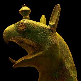 Bronze griffin protome, mystical animal head sculpture made of green material with detailed design,