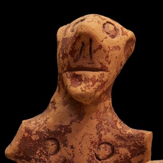 Anthropomorphic votive statuette, clay figure with abstract facial features and antique-looking