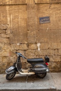 Cairo, Egypt. July 7th 2024 A grey coloured scooter parked in the narrow alley ways of the