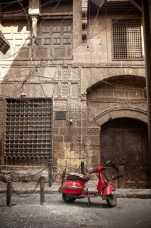 Cairo, Egypt. July 7th 2024 A cool looking red scooter parked in front of typical Egyptian
