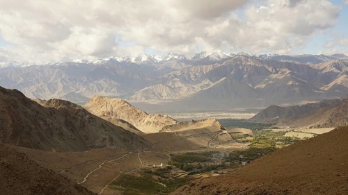 Mountain landscape with cloudy sky, snowy peaks in the background, trekking in Ladakh, Himalayas,