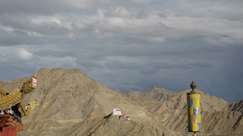View towards Namgyal Tsemo monastery, dramatic sky with pediment of a Buddhist temple with Tibetan