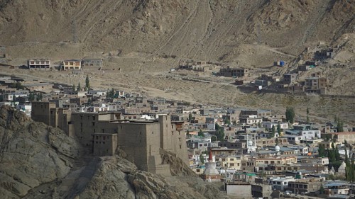 View of the Leh Palace from a hill with Leh in the background in a desert-like environment with
