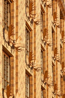 Yellow house, with a water-strewn brick façade and decorated with 52 moose shovels and hunting