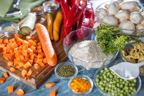 Fresh ingredients and spices such as peppers, peas, rice, mushrooms and sliced carrots