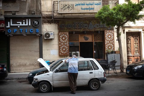 Cairo, Egypt. June 24th 2024 An Egyptian man waits by his broken down car in the summer heat of