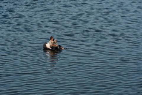 Qanater, Nile Delta. Egypt. December 18th 2022 An Egyptian man fishing from a makeshift inflatable