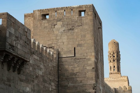 Minaret of the Al Hakim Mosque with the fortified defensive Northern walls of Islamic Cairo, near